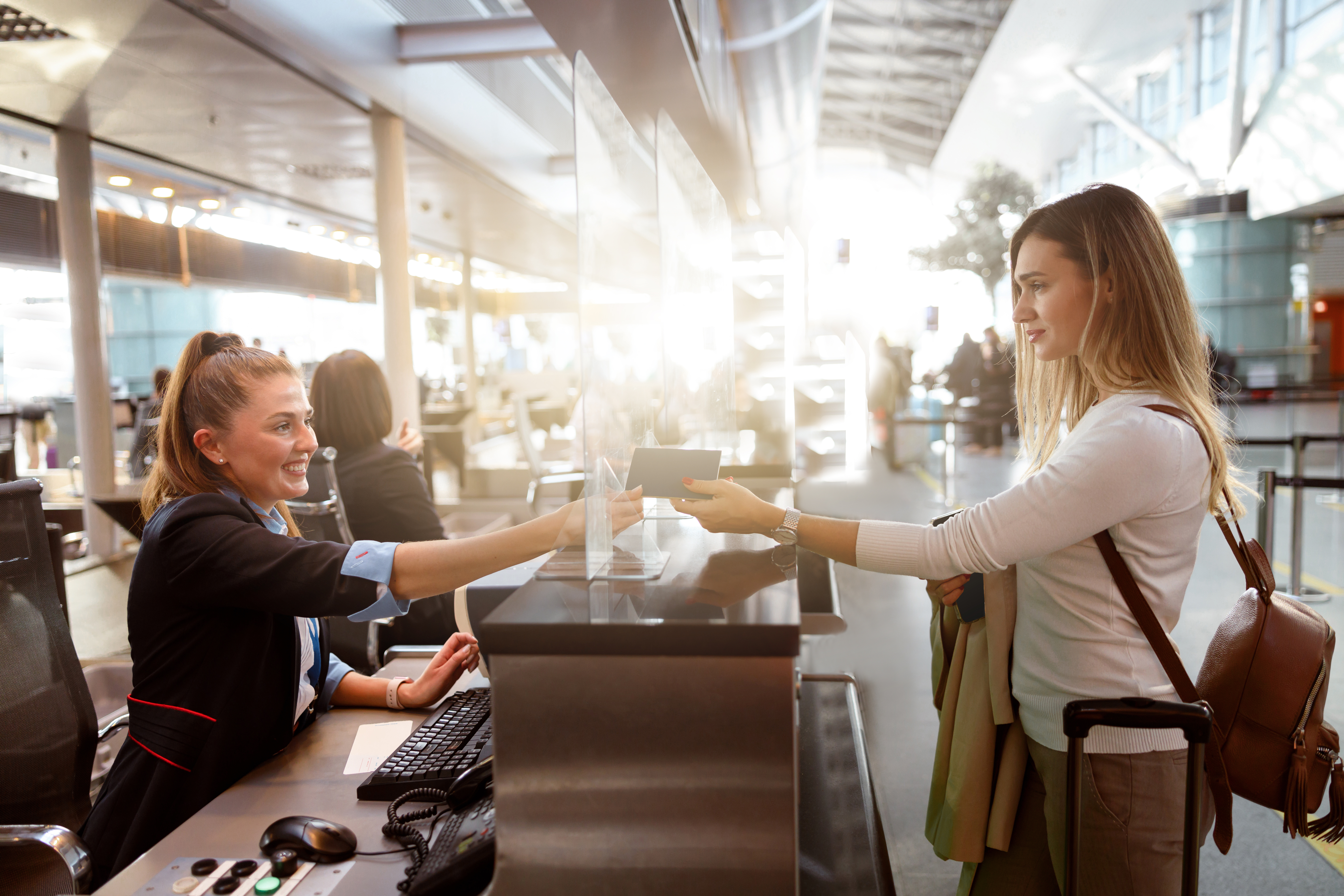 Female traveler giving her passport to an airport staff member